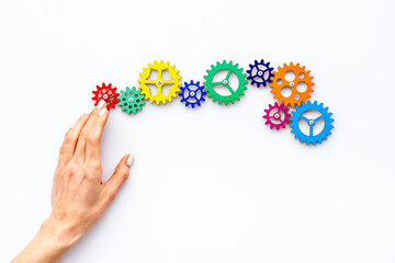 Teamwork concept. Hand connecting gears into puzzle - symbol of working mechanism