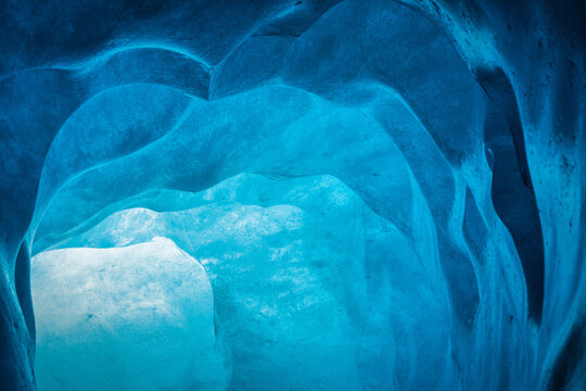 blue ice inside a cave under melting rhone glacier