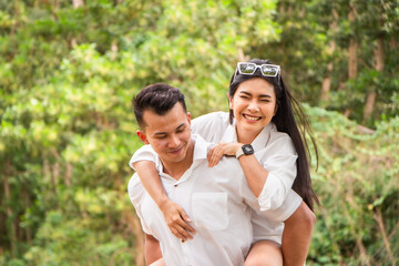 Asian couple love having fun. man and woman wearing casual clothing feeling happiness in park