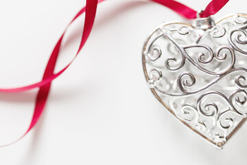 Saint Valentine day greeting card, beautiful silver heart with ribbon on white