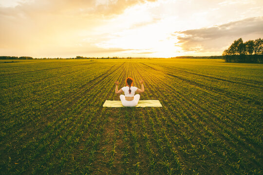 Curvy girl doing yoga in nature.