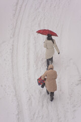 people walk along snow-covered streets in a blizzards