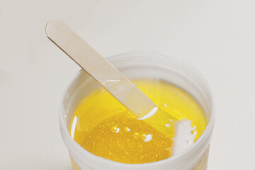 A close up shot of hair removal wax with a stick.