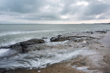 Wave splashing at the rocks, long exposure