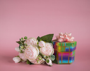 Gift box and bouquet of flowers on pink background. The concept of congratulations for Valentine's Day, birthday, International Women's day and other holidays. Copy space