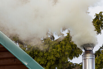 Smoke comes from the chimney. Soot air pollution concept.