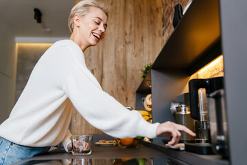 Smiling young woman making tea