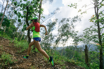 Fitness woman runner running on summer forest trail