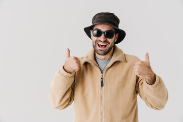 Portrait of man wearing beige jacket, cap and sunglasses