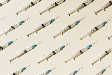 COVID-19 vaccine syringes on yellow background
