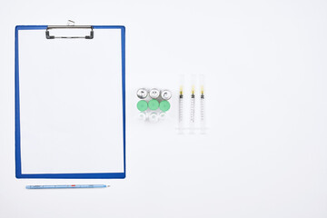 Fototapeta na wymiar Covid-19 vaccine with medical supplies. Medical background with vaccine vial, syringe, medical gloves and cardboard with copy space. Vaccine protects against new Coronavirus