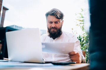 Concentrated man working with papers in cafe