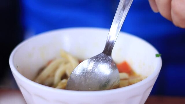Eating lagman with a spoon