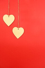 Valentine background. 2 wooden hearts hung with rope on a red background. Valentine concept. Flat view, top view, copy space
