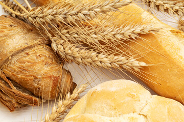 Ears of wheat with baguette, wholemeal sandwich, and rosette bread