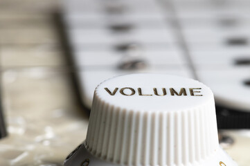 Close-up of electric guitar pickups and volume knob