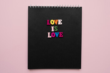 words love is love, notepad with chalk drawn heart. Valentine's day concept