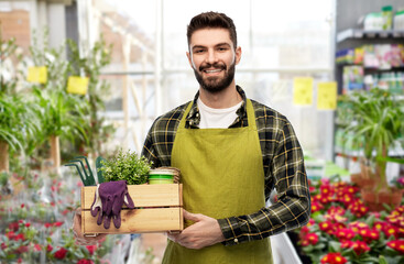 gardening, farming and people concept - happy smiling male gardener or seller in apron with box of...