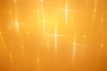 orange abstract background with blurred quadrilateral rays asterisks highlights and flare