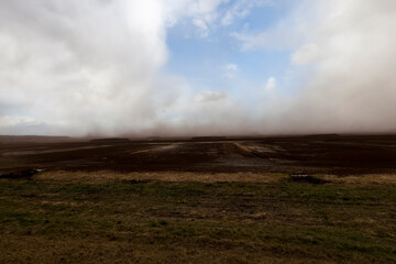 dust from peat excavations flying against the sky