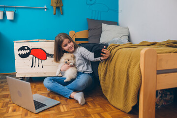 little girl playing with her puppy at home