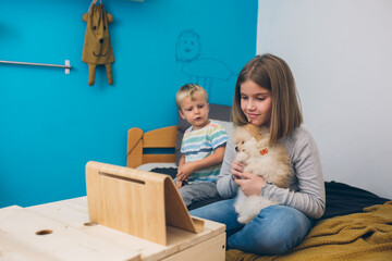 Fototapeta premium brother and sister having great time together playing with their puppy