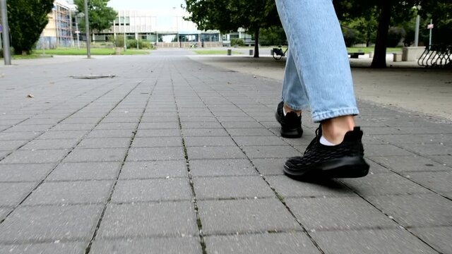 stepping Person. Student legs walking around the city wear in blue jeans,  feet stepping on square outdoors in autumn Prague, close up walk Forward