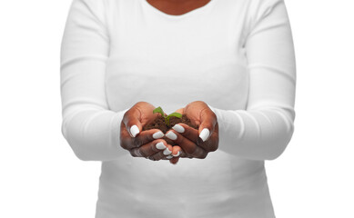 ecology, environment and nature concept - close up of young african american woman holding plant growing in handful of soil on white background