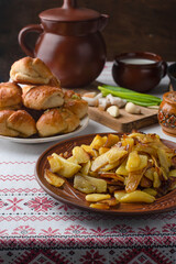 Ukrainian or Russian traditional feast. Fried potatoes with bacon. Ukrainian ornament. Copy space