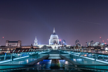 london millenium bridge at night with illuminated building of st pauls cathedral at the background