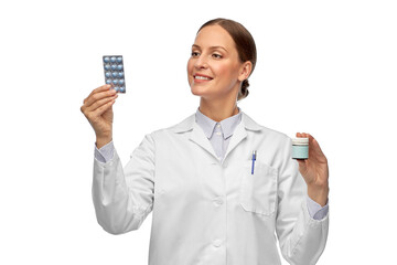 medicine, profession and healthcare concept - happy smiling female doctor comparing pills in jar...