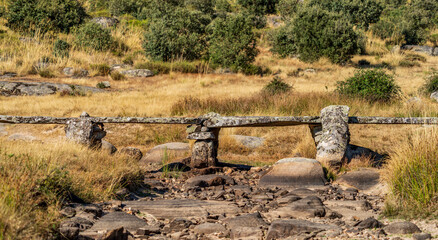 Antique stone boulders bridge over dry river