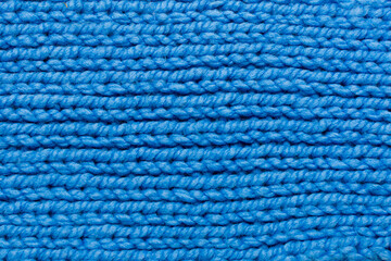 Knitted pattern of blue threads. Horizontal photo, drawing close-up. The pattern is made with knitting needles