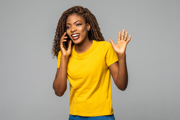 Young african woman talking phone isolated on gray background