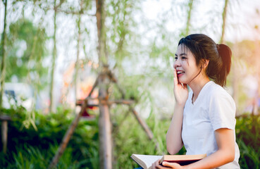 Fototapeta premium The young woman happily reading the book alone Education and knowledge is a good thing.