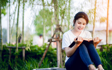 The young woman happily reading the book alone Education and knowledge is a good thing.