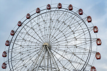 Fototapeta premium Ferris wheel on blue cloudy sky background