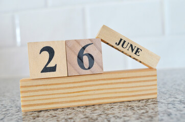 June 26, Cover design with number cube on a white background and granite table.