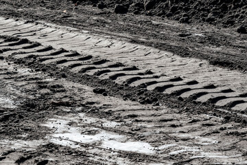 Trail of car tires on a clay road.