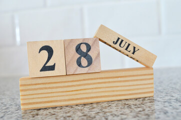 July 28, Cover design with number cube on a white background and granite table.