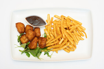 French fries with salad and meatballs on white plate