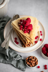 Assiette de crêpes avec framboises et groseille sur table
