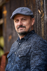 Farmer by a wooden wall of a barn