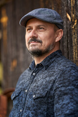 Farmer by a wooden wall of a barn