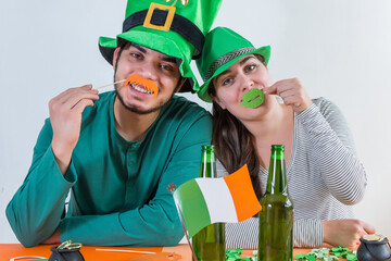 Young boy and girl with green leprechaun hat, celebrate happily Saint Patrick's Day, cheering with...