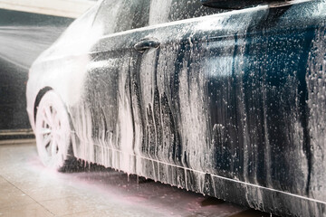 Naklejka na ściany i meble Applying foam to the car. Professional auto wash