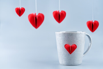 Grey background with red pepper hearts for Valentine's day and a cup