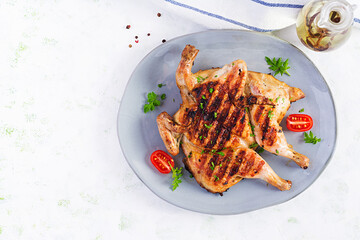 Grilled chicken Tabaka on blue plate. Georgian cuisine. Top view, above