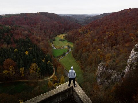 Panorama view of hiker on rock castle ruins Wartstein in Grosse Lauter valley Muensingen Gundelfingen Hayingen Germany