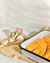 food composition of baked pumpkin with dried seasoning and a bunch of fresh garlicon a light background The idea of healthy eco-friendly natural food. Selective focus. Place for text
